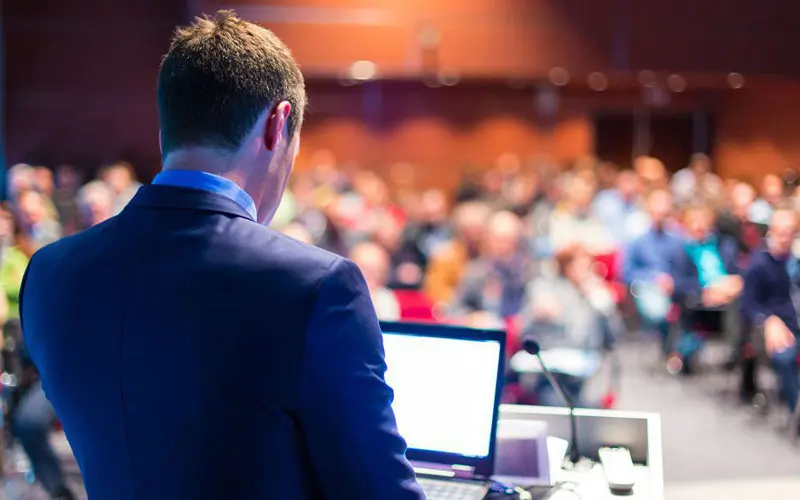 Man speaking to an auditorium of people